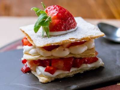 Closeup of a tasty dessert of millefoglie pastry, cream, and strawberries, from a cooking vacation with The International Kitchen.