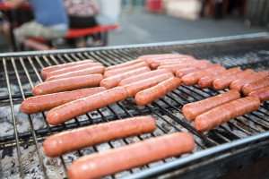 Hot dogs on the grill during a traditional Fourth of July American Independence Day celebration.