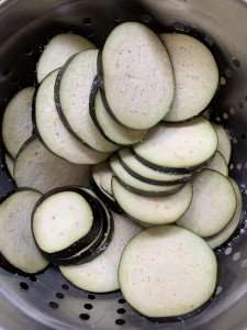 Sliced eggplant, salted and draining.