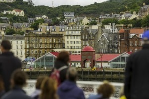 Travelers on a ferry in Oban Harbor looking back toward the city