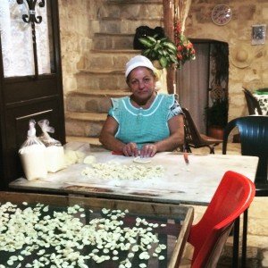 A local woman making homemade orecchiette pasta in old Bari on a culinary vacation in Puglia
