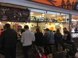 Locals enjoying fabulous food at the Mercat del Ninot on a foodie tour of Barcelona