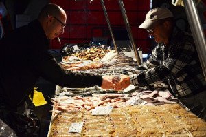 Buying fish in Italy at the market during an authentic cooking vacation