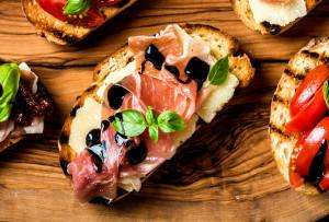 An appetizer featuring grilled bread and prosciutto on our Italy food tours.