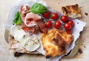 Traditional Italian products on an Italy food tour, including prosciutto, mozzarella, and more.