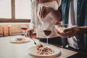 Cooking spaghetti together on a romantic cooking vacation in Italy.