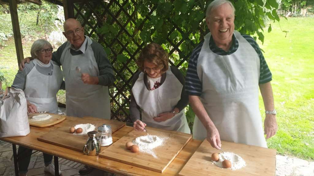 Making homemade pasta with friends during a Tuscany cooking vacation with The International Kitchen.