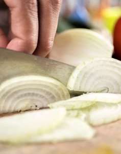 Slicing onion during a cooking class with The International Kitchen.