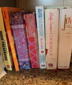 Old favorite cookbooks lined up on the shelf.