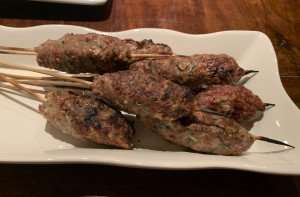 Closeup of lamb kofta kebabs on skewers.