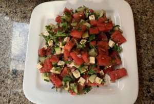 A salad of watermelon, cucumber, feta, and fresh herbs.