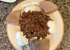 A tasty plate of Ramazan kebabi with yogurt dressing and pita.