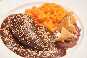 Tasting a delicious poblano dish with mole on a culinary vacation in Mexico.