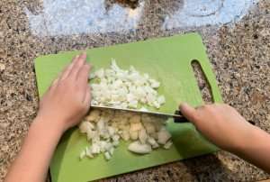 Learning to chop onions during a cooking class.