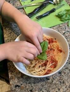 Plating a dish of spaghetti with homemade tomato sauce.