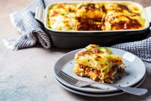 Traditional Greek Moussaka, a baked, layered dish with eggplant, potato, meat, and béchamel.