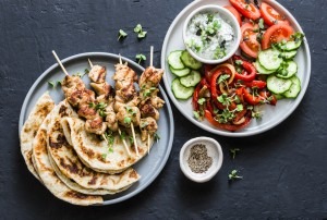 Grilled chicken souvlaki with pita and condiments.