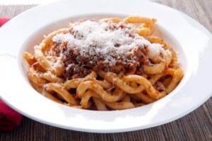 Pici pasta with lamb ragu and parmesan cheese in Tuscany.