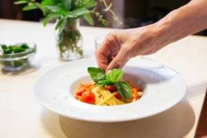 Plating a simple plate of pasta during your culinary vacation.